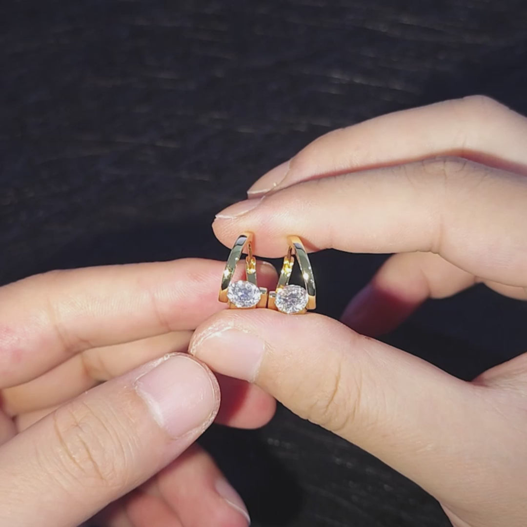 Hand holding both white gold and yellow gold plated silver Moissanite Solitaire Twist Hoop Earrings in 925 sterling silver, showing off moissanite sparkle, side by side - Sensitive Stones