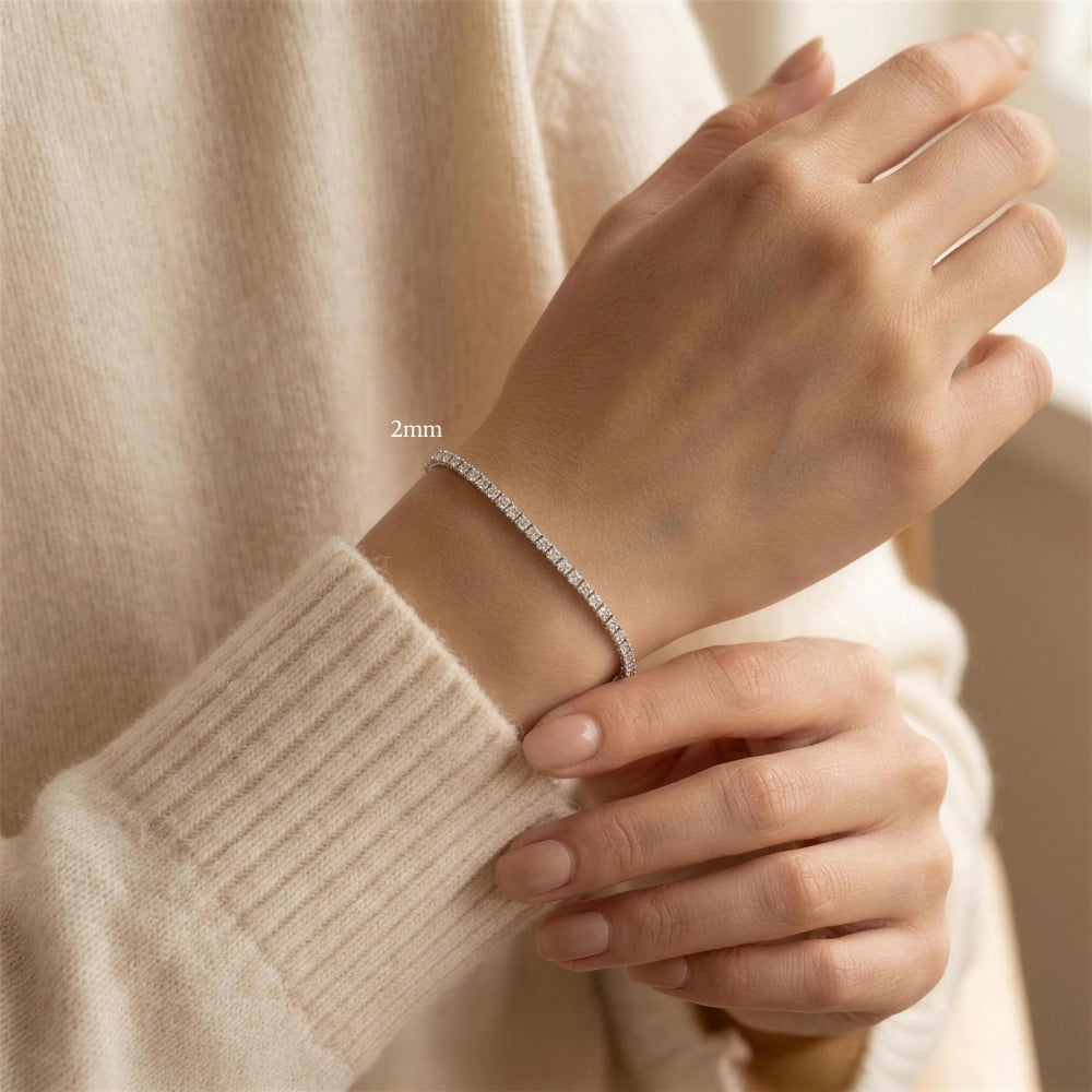 Woman wearing a 2mm princess cut moissanite tennis bracelet, wrist resting on a cream cashmere sleeve - Sensitive Stones