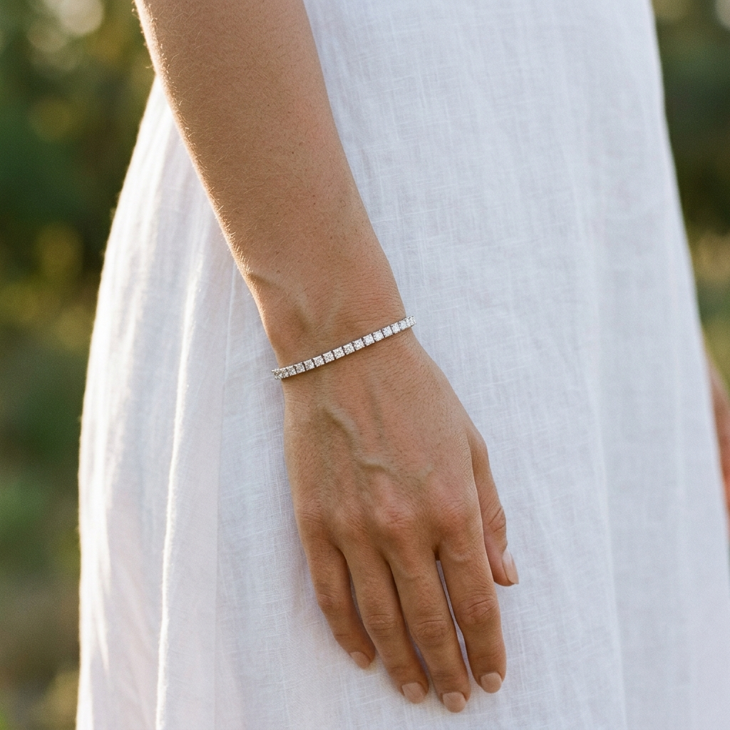 Woman wearing a 3mm princess cut moissanite tennis bracelet, standing outdoors in a white linen dress at golden hour - Sensitive Stones