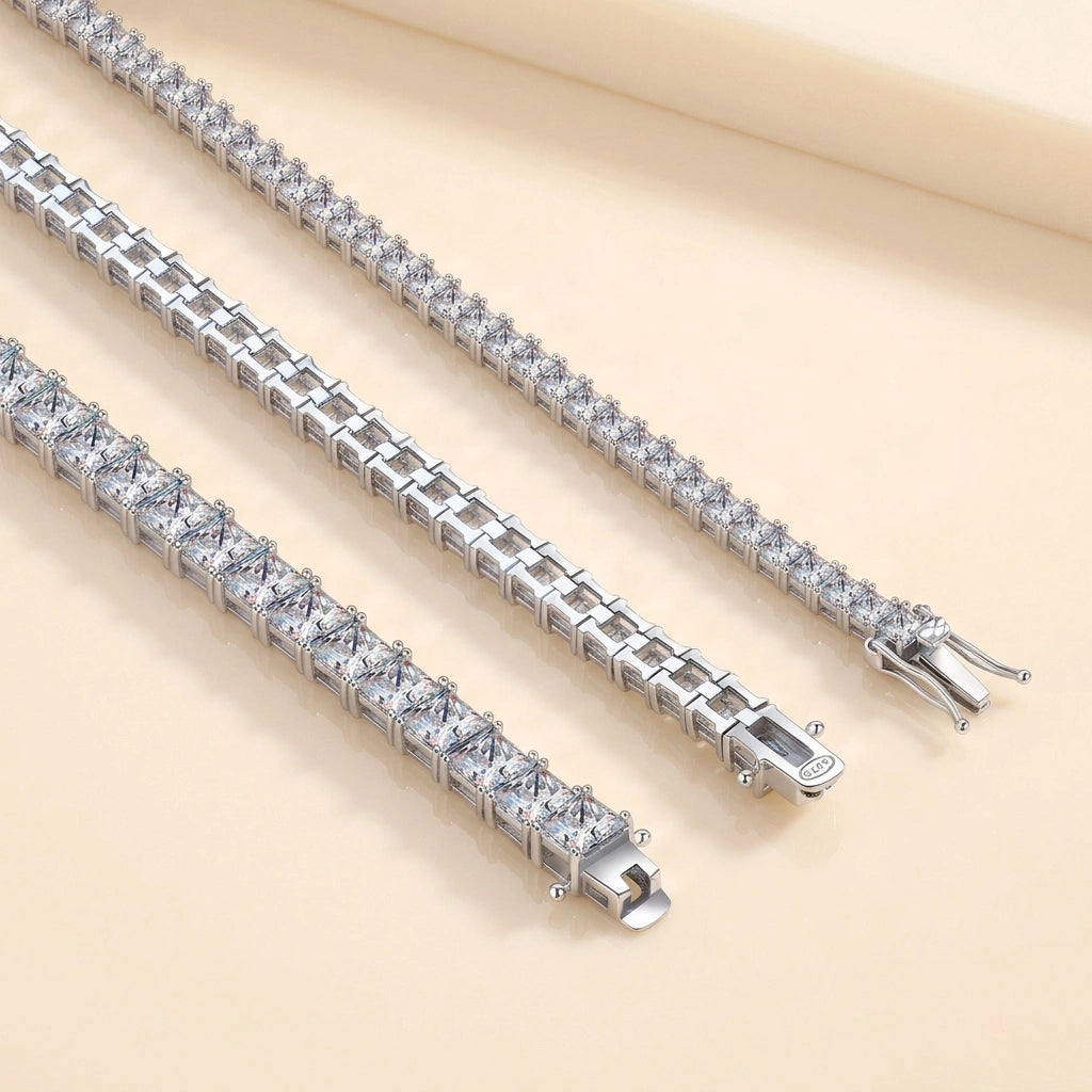 Three princess cut moissanite tennis bracelets in different stone sizes laid diagonally on a cream background - Sensitive Stones