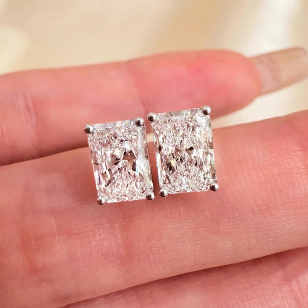 Radiant cut moissanite stud earrings held to show crushed-ice sparkle - Sensitive Stones