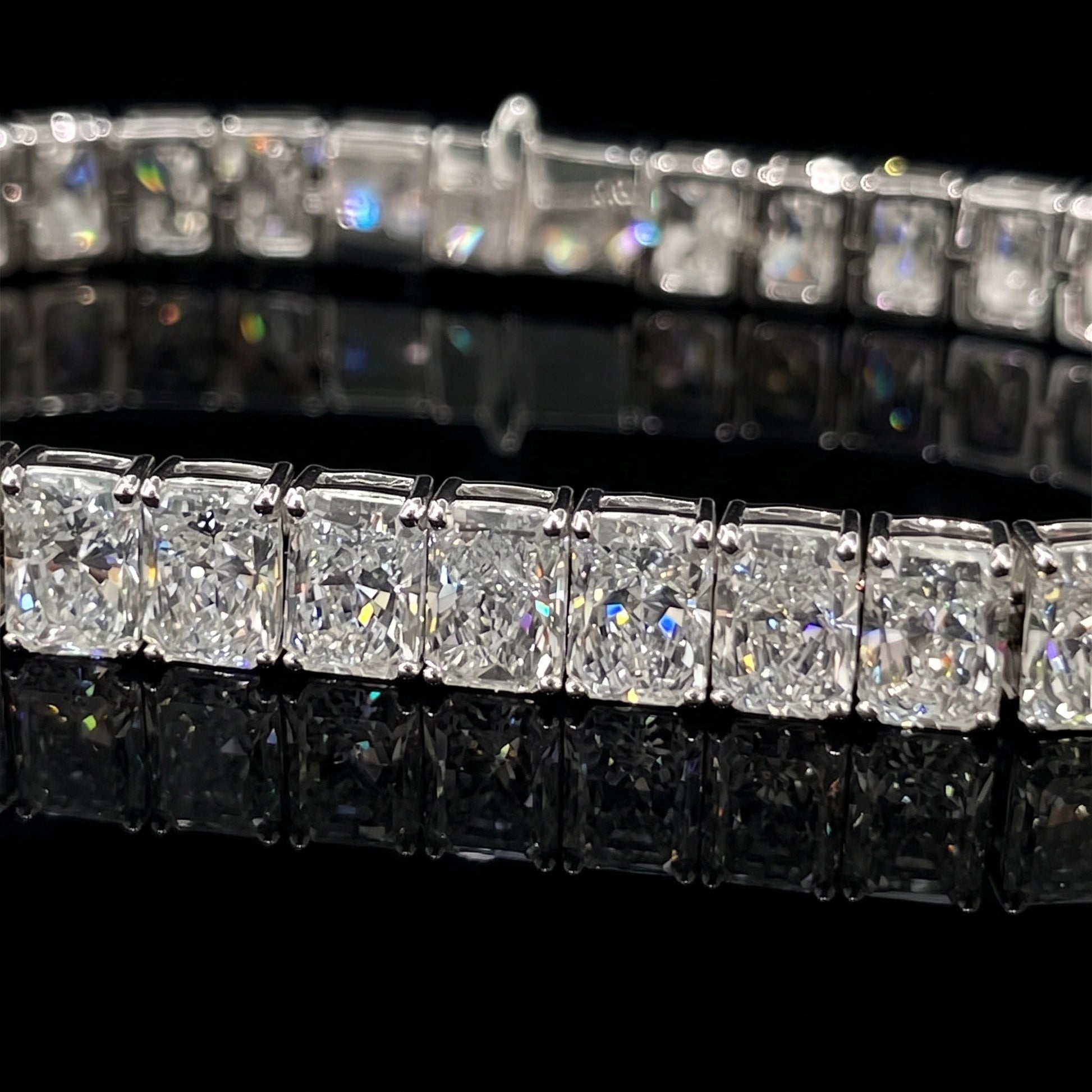 Radiant cut moissanite tennis bracelet on a black background showing sparkle and reflection