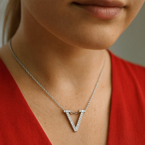 Moissanite initial ‘V’ necklace with D-color VVS1 stones set on a rhodium-plated 925 sterling silver chain, shown on model in red top - Sensitive Stones