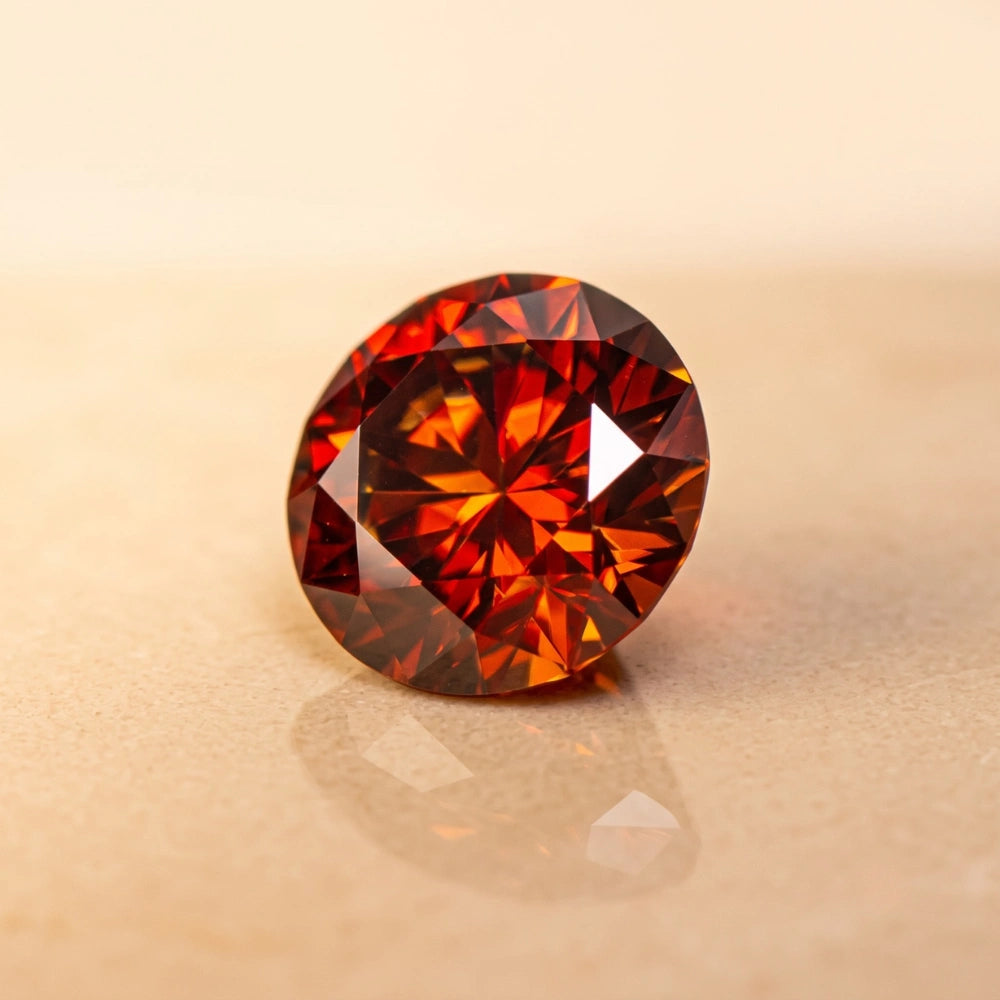 Close-up of a round brilliant-cut red moissanite stone showing fire and facets - Sensitive Stones
