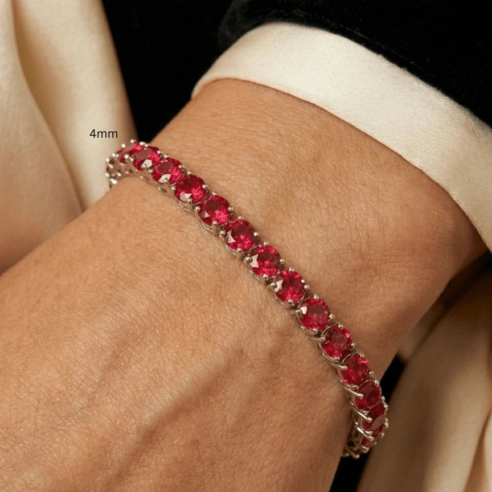 4mm Red moissanite tennis bracelet worn on wrist with cream silk sleeve, showcasing fiery round-cut stones in sterling silver 4-prong setting - Sensitive Stones