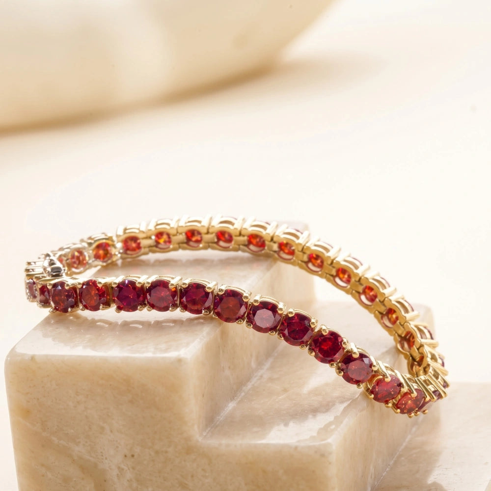 Curved view of red moissanite tennis bracelet in yellow gold plated silver illustrating flexibility and gleam – Sensitive Stones