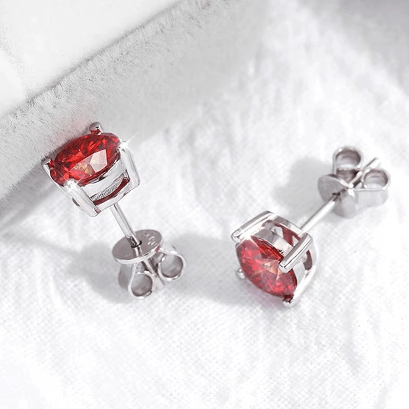 Pair of red moissanite stud earrings on a white textured background - Sensitive Stones