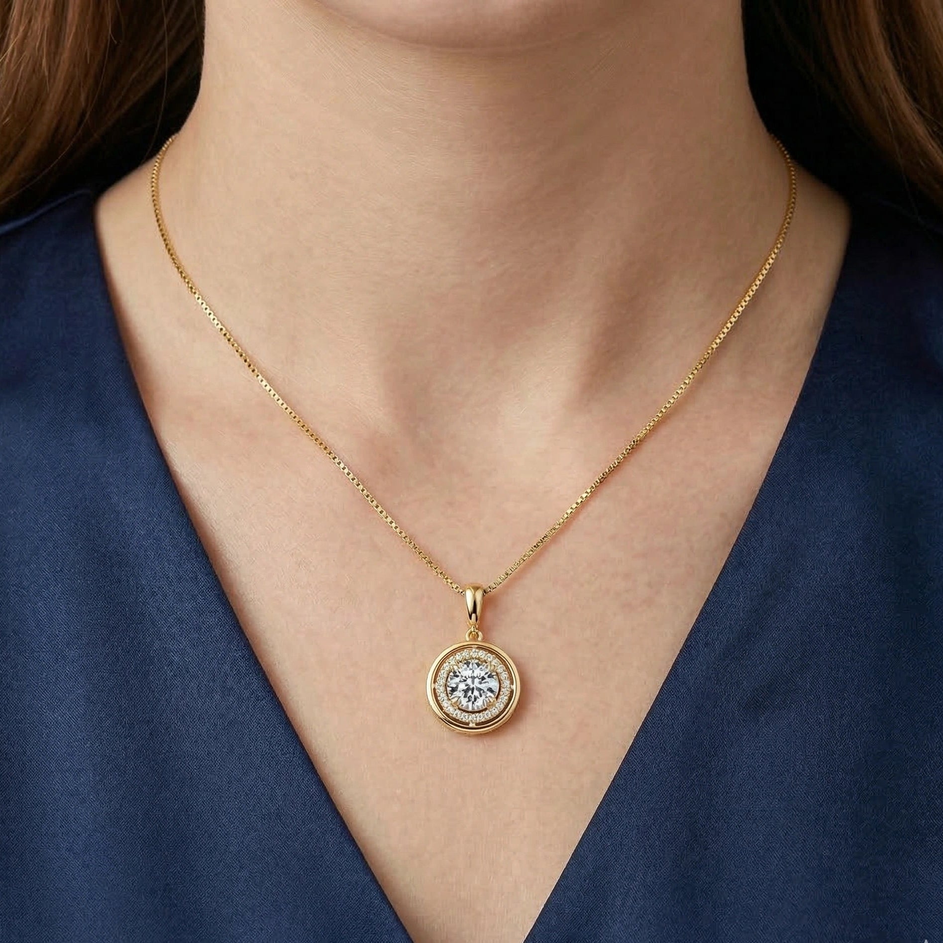 Round moissanite halo pendant necklace in 925 sterling silver and 18k gold finish worn by a woman against a dark blue outfit - Sensitive Stones