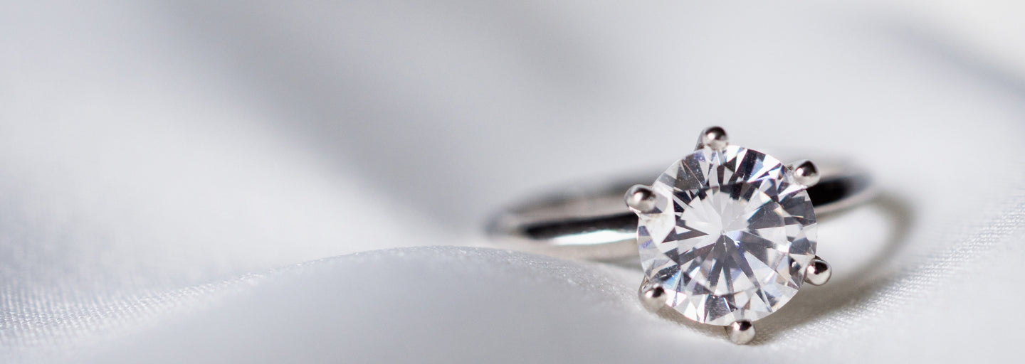 Solitaire moissanite ring on satin background – track your Sensitive Stones order online anytime