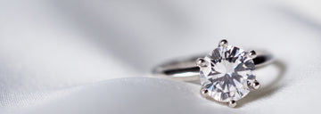 Solitaire moissanite ring on satin background – track your Sensitive Stones order online anytime