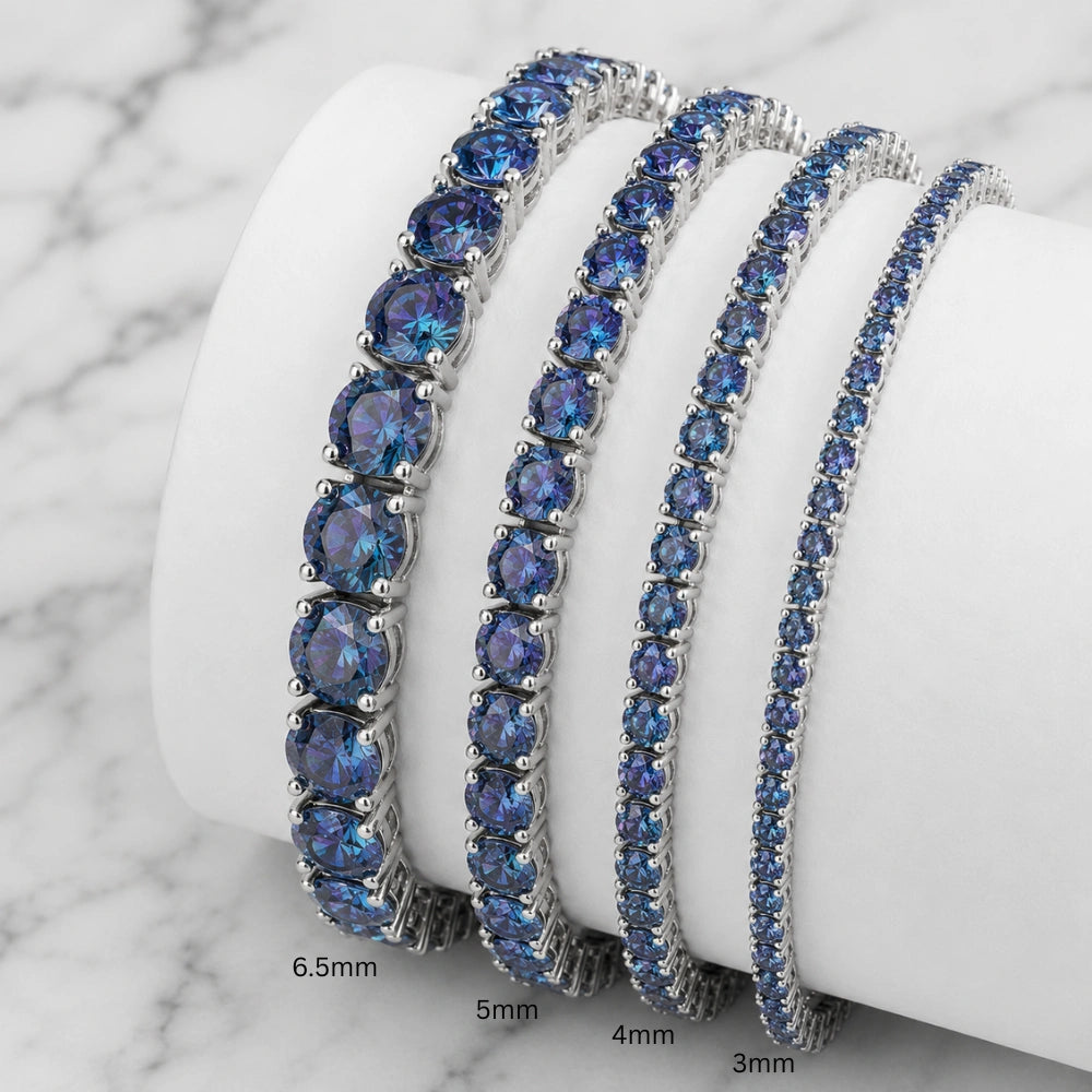 Set of blue moissanite tennis bracelets in black gold plating on a white stand with sizes 3mm, 4mm, 5mm, 6.5mm - Sensitive Stones
