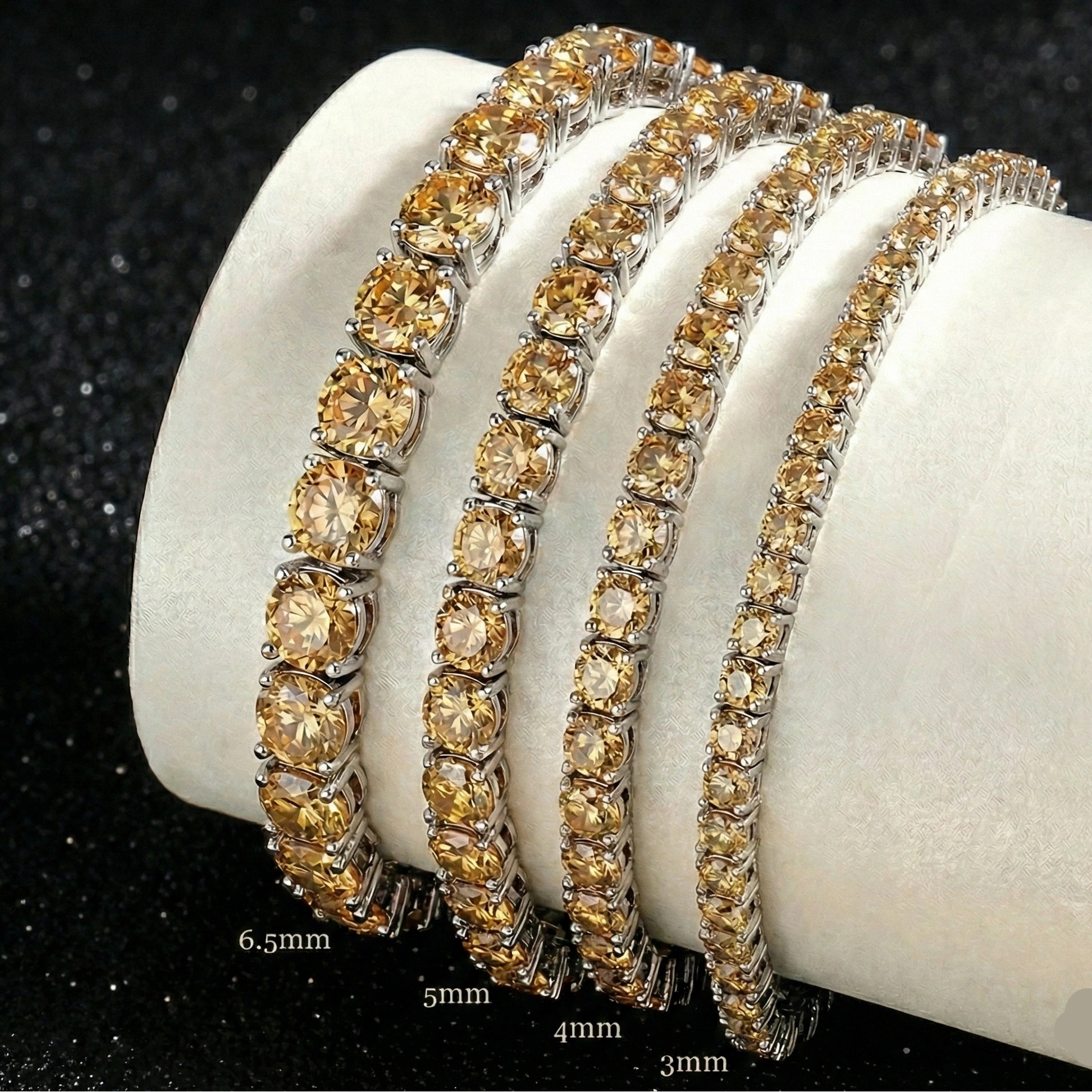 Set of champagne yellow moissanite tennis bracelets in black gold plating on a white stand with sizes 3mm, 4mm, 5mm, 6.5mm - Sensitive Stones