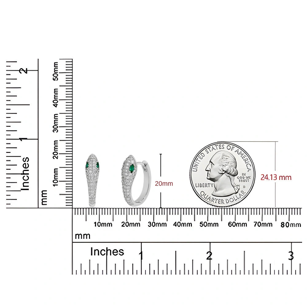 A pair of silver moissanite snake huggie hoop earrings with green gemstone accents, shown with measurement rulers and a US quarter coin for scale on a white background - Sensitive Stones