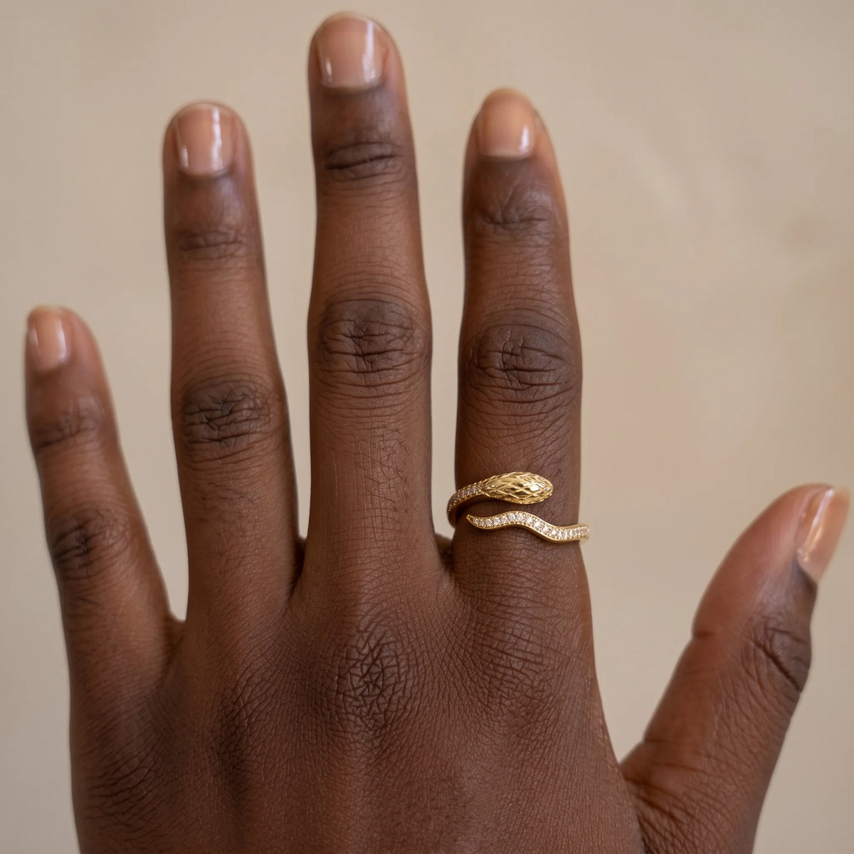 Hand wearing the snake half eternity moissanite ring in a yellow gold finish, a dainty pavé snake wrap ring - Sensitive Stones