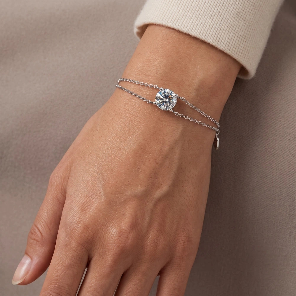A woman's wrist wearing a white gold moissanite solitaire double chain bracelet with a single round 1ct D color stone - Sensitive Stones