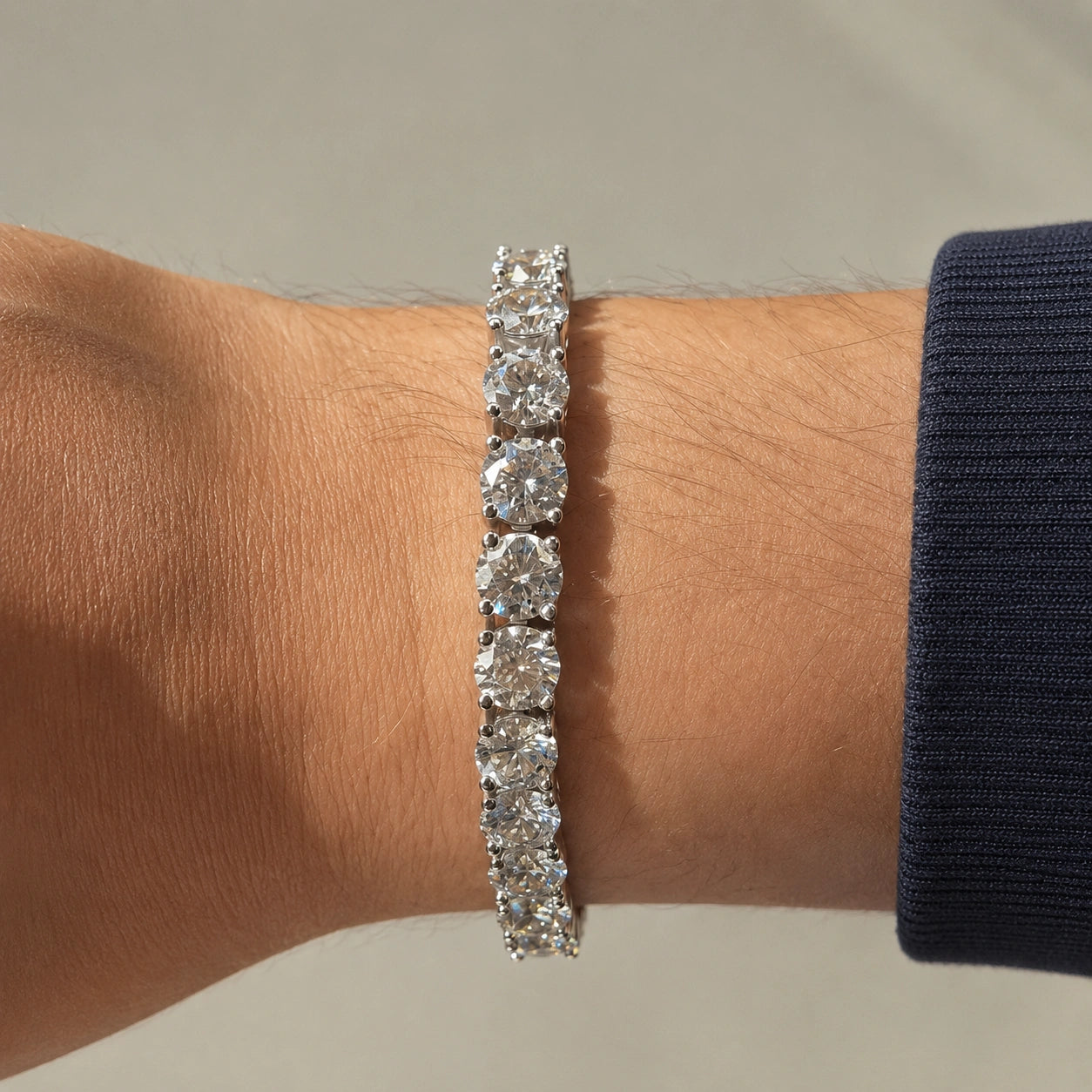 6.5mm statement moissanite tennis bracelet in 18K white gold worn on a man's wrist, claw set round D Color VVS1 stones - Sensitive Stones