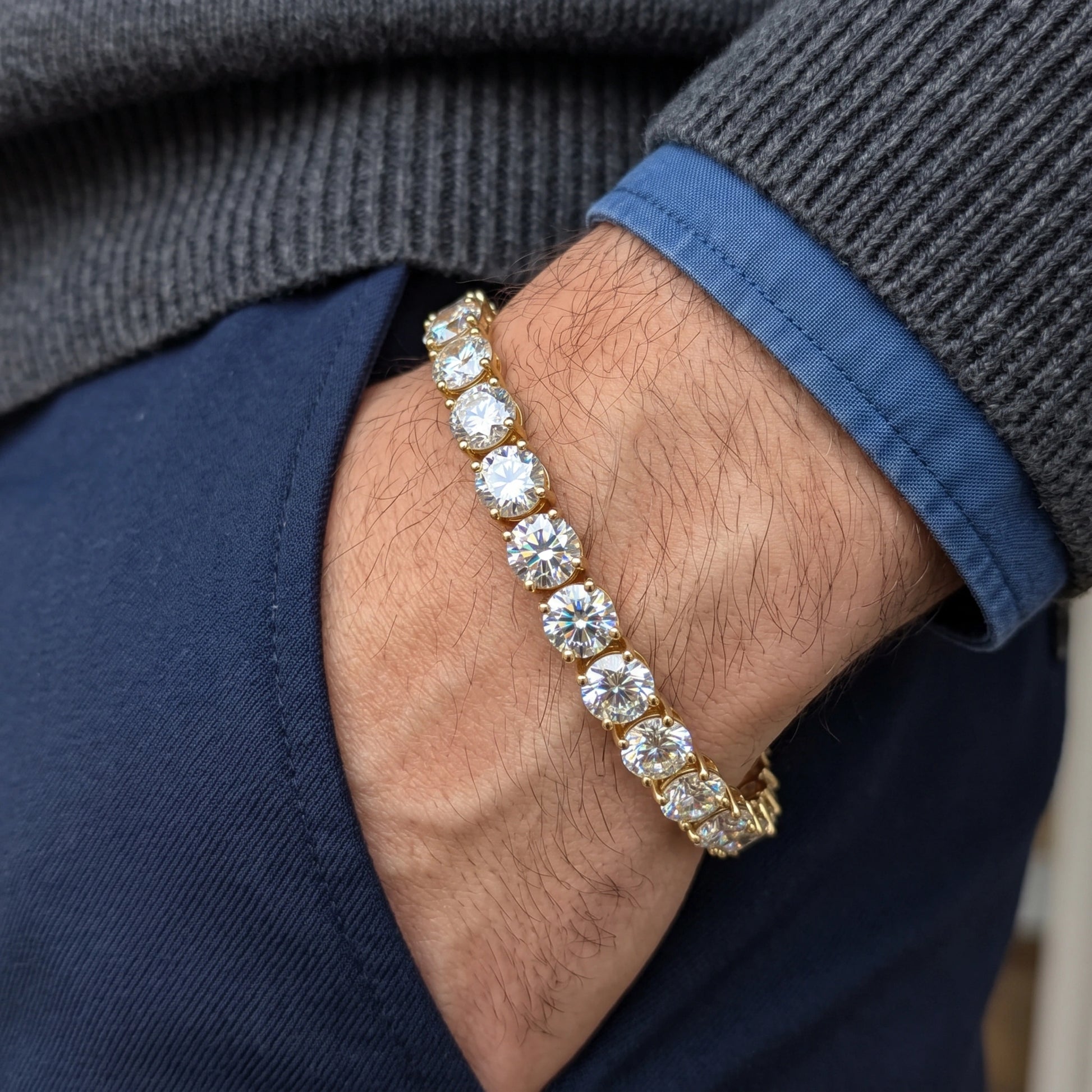 6.5mm statement moissanite tennis bracelet in 18K yellow gold worn on a man's wrist, claw set round D Color VVS1 stones - Sensitive Stones