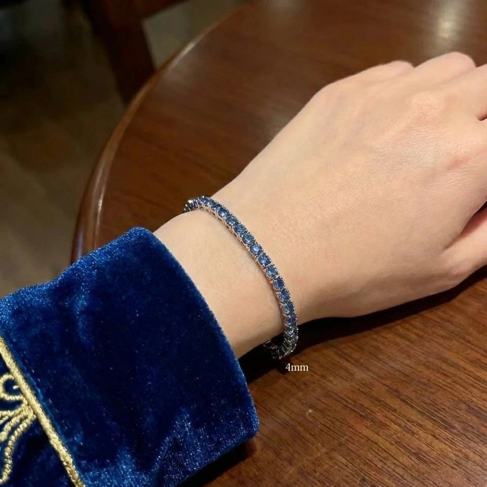 925 sterling silver blue moissanite tennis bracelet with VVS1 round-cut stones worn on wrist with blue velvet sleeve - Sensitive Stones