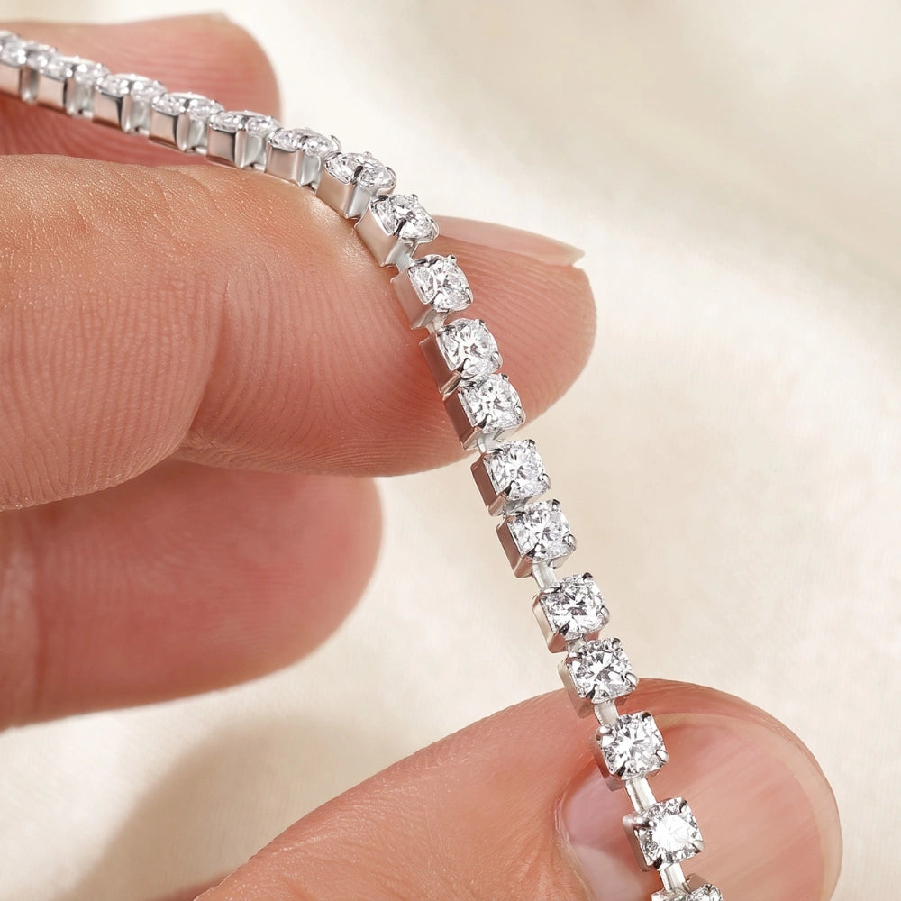 Close-up of a white gold stretch moissanite tennis bracelet showing the 4-prong round D color VVS1 stones and elastic cord - Sensitive Stones