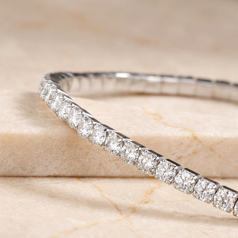 Close-up of a white gold stretch moissanite tennis bracelet showing the round D color VVS1 stones and elastic band - Sensitive Stones