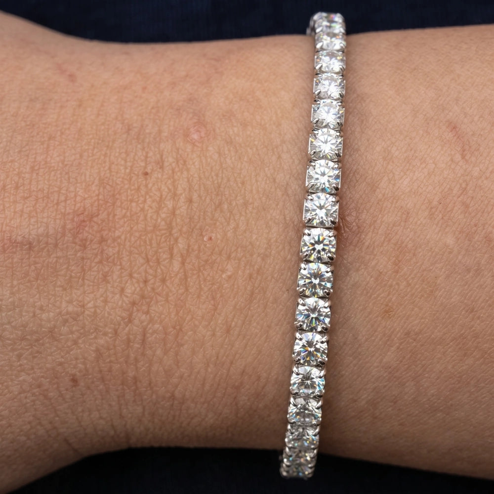 A white gold stretch moissanite tennis bracelet worn on the wrist, close-up of the round D color VVS1 stones - Sensitive Stones
