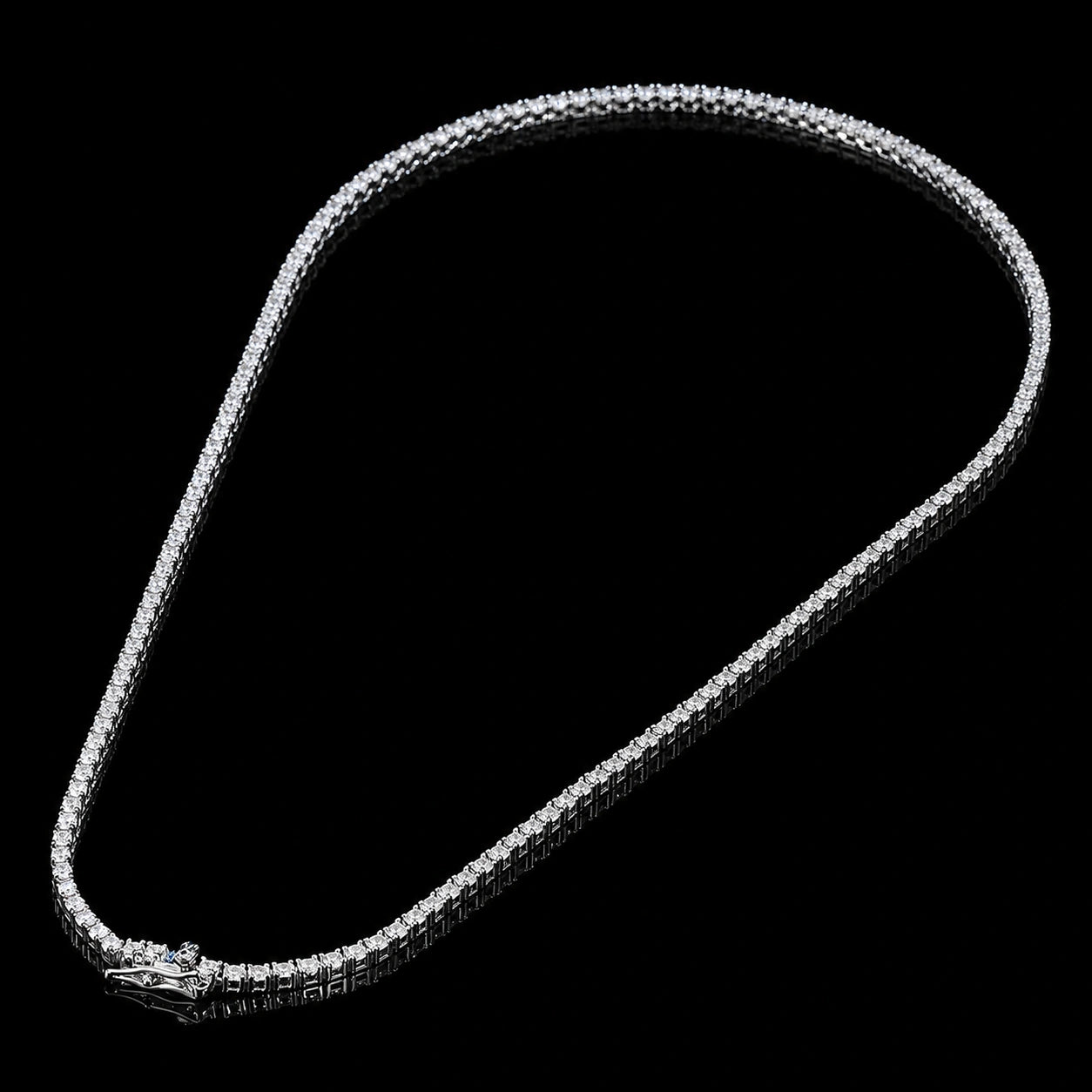 White moissanite tennis necklace full view on black background, white gold plated 925 sterling silver, 4-prong round stones, box clasp with safety catch - Sensitive Stones