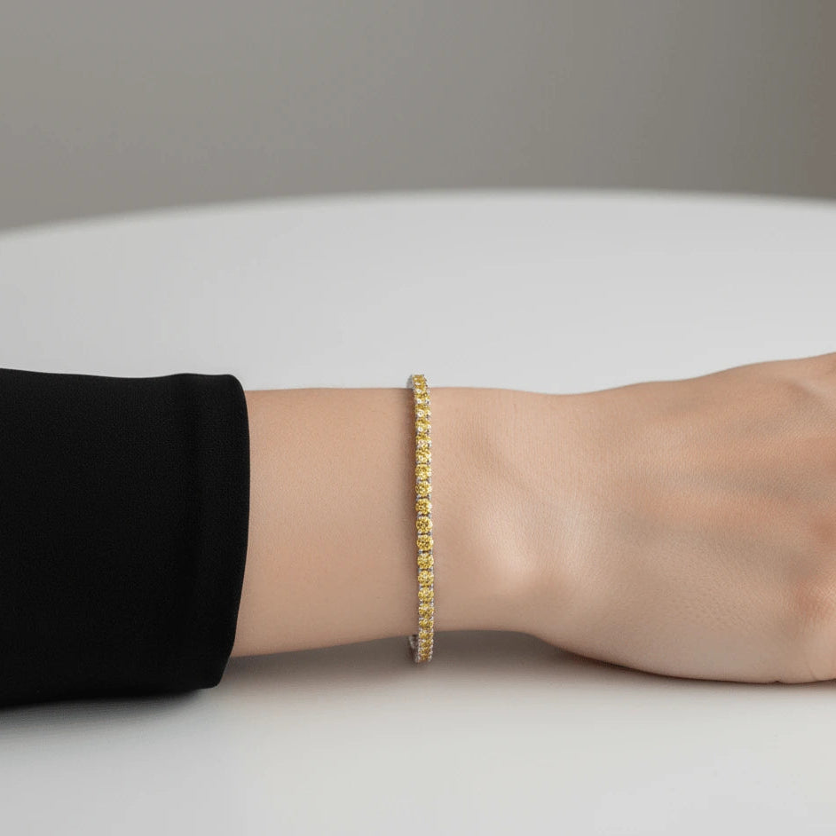 Yellow moissanite tennis bracelet with round cut stones on wrist, sterling silver setting, minimalist background – Sensitive Stones
